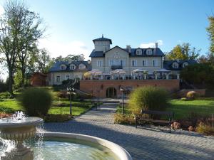 a large house with a fountain in front of it at Talaria Resort&SPA in Trojanów