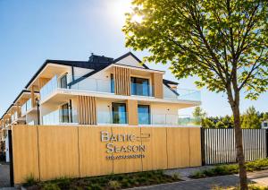a building with a fence in front of it at Baltic Season Spa Apartments in Grzybowo