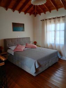 a bedroom with a large bed with pink pillows at Agapis Apartments in Petra