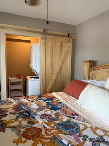 a bedroom with a bed and a kitchen with a refrigerator at Rising Sun Rustic Retreat in Roach