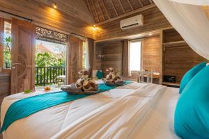 a bedroom with a large bed with two animals on it at D'Gume Villas Lembongan in Nusa Lembongan