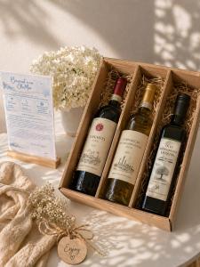 a crate of three bottles of wine on a table at ClaMar Apart Hotel in Porto Ercole