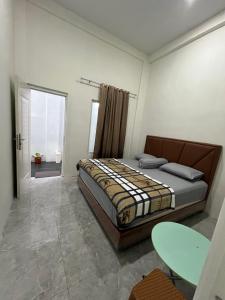 a bedroom with a bed and a table in it at Nok Homestay in Pangururan