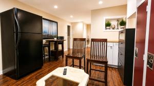 a kitchen with a black refrigerator and a table at Tuscan Ridge Guesthouse Calgary West in Calgary