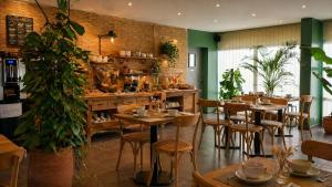 a restaurant with wooden tables and chairs and plants at Les Jardins de L'Ocean - Climatisé in Biscarrosse-Plage
