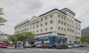 a large white building with cars parked in a parking lot at Bugok Hanseong Hotel in Changnyeong