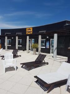 a group of chairs and lounge chairs on a patio at Linda Bay Resort Apt 302 in Mar de las Pampas
