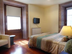 a bedroom with a bed and a tv on the wall at Hotel Jauregi Borda in Maya del Baztán