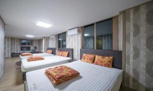 two beds sitting in a room with windows at Bugok Hanseong Hotel in Changnyeong +107 photos