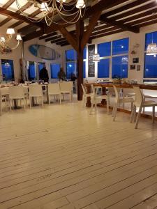 Un comedor con sillas y mesas blancas y ventanas. en Linda Bay Resort Apt 302, en Mar de las Pampas