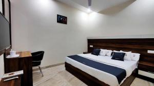 a bedroom with a bed and a desk and a television at hotel chandigarh pavilion in Chandīgarh