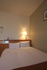 Postel nebo postele na pokoji v ubytování Toyooka Sky Hotel