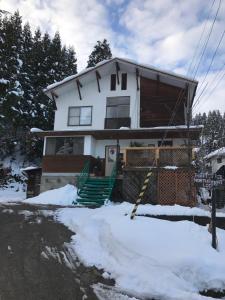 a house with snow in front of it at North Point Lodge in Minami Uonuma