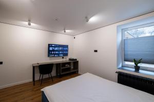 ein Schlafzimmer mit Bett, Schreibtisch und Fernseher in der Unterkunft N17 Hotel in Poltawa