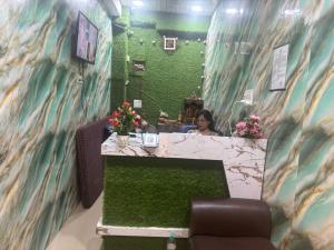 a woman sitting at a counter in a hair salon at Hotel Youvraj Inn in Ghaziabad