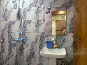 a bathroom with a sink and a mirror at Hotel Youvraj Inn in Ghaziabad