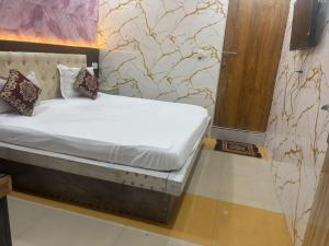 a small bed in a room with a door at Hotel Youvraj Inn in Ghaziabad