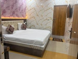 a small bed in a room with a door at Hotel Youvraj Inn in Ghaziabad