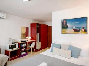 a bedroom with a bed and a desk with a computer at Xin Hotel at Udomsuk 25 in Bangna