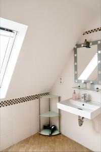 a bathroom with a sink and a mirror at Pension Seehund in Norddeich in Norden +26 photos