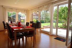 a dining room with a table and chairs and a large window at Pension Seehund in Norddeich in Norden