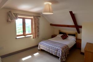 a bedroom with a bed and a window at Beacons View Farm Cottages in Merthyr Cynog