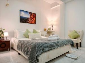 a white bedroom with a bed and a couch at Xin Hotel at Udomsuk 25 in Bangna +31 photos