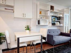 a kitchen with a table and chairs and a couch at Xin Hotel at Udomsuk 25 in Bangna