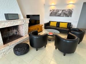 a living room with leather furniture and a fireplace at Villa La Gavina Sea View Pool and Beaches in Blanes