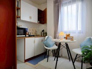 a kitchen with a table and chairs and a window at Xin Hotel at Udomsuk 25 in Bangna