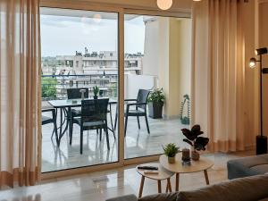 a living room with a view of a table and chairs at Elenas sweet home - Penthouse with Large Balcony in Pyrgos