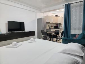 a bedroom with a white bed and a living room at Mamaia Nord Resort Premium in Mamaia Sat/Năvodari +287 photos