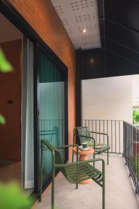 two green chairs sitting on a balcony at Easterly Room 01 in Chanthaburi
