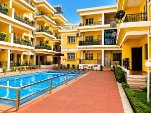 a hotel with a swimming pool in front of a building at Tony apartment baga in Baga
