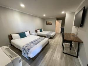 a hotel room with two beds and a desk at After 3 Inn in Alhambra
