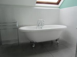 a white bath tub in a bathroom with a window at Earlston House in Paignton