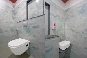 a bathroom with a white toilet and a window at Accuotel Inn RG Grand in Kanāria