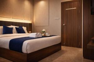 a bedroom with a large bed with a wooden door at Accuotel Inn RG Grand in Kanāria +15 photos