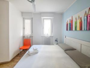 a bedroom with a large bed and a orange chair at B&B Color Rovereto in Rovereto