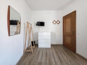 a room with a mirror and a dresser and a door at B&B Color Rovereto in Rovereto