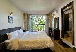 a bedroom with a large bed and a large window at Sagarmatha Apartment Hotel in Pātan +143 photos