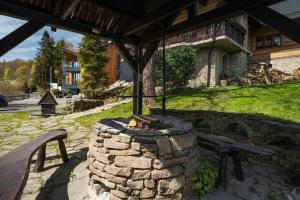 a stone fire pit in a yard with a bench at Dom dla 16 osób z bilardem - Ino Zajrzyj in Ustroń