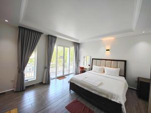 a bedroom with a large bed and large windows at Kampot Origin in Kampot