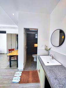 a bathroom with a sink and a toilet and a table at Kampot Origin in Kampot +74 photos
