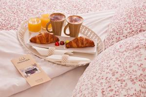 a tray of breakfast foods and drinks on a bed at Hotel Provenza in Ventimiglia
