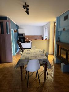 a living room with a table and chairs and a kitchen at Gîte du petit niglo in Droyes +5 photos