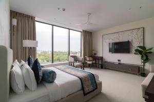a bedroom with a large bed with a large window at Hotel Lohara Inn in Chandrapur +17 photos