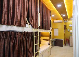 two bunk beds in a room with curtains at Mithila Dormitory in Navi Mumbai +42 photos