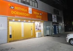 a store front with yellow doors and a car parked outside at Mithila Dormitory in Navi Mumbai