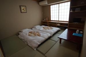 a bed in a small room with a window at Annex Katsutaro Ryokan in Tokyo
